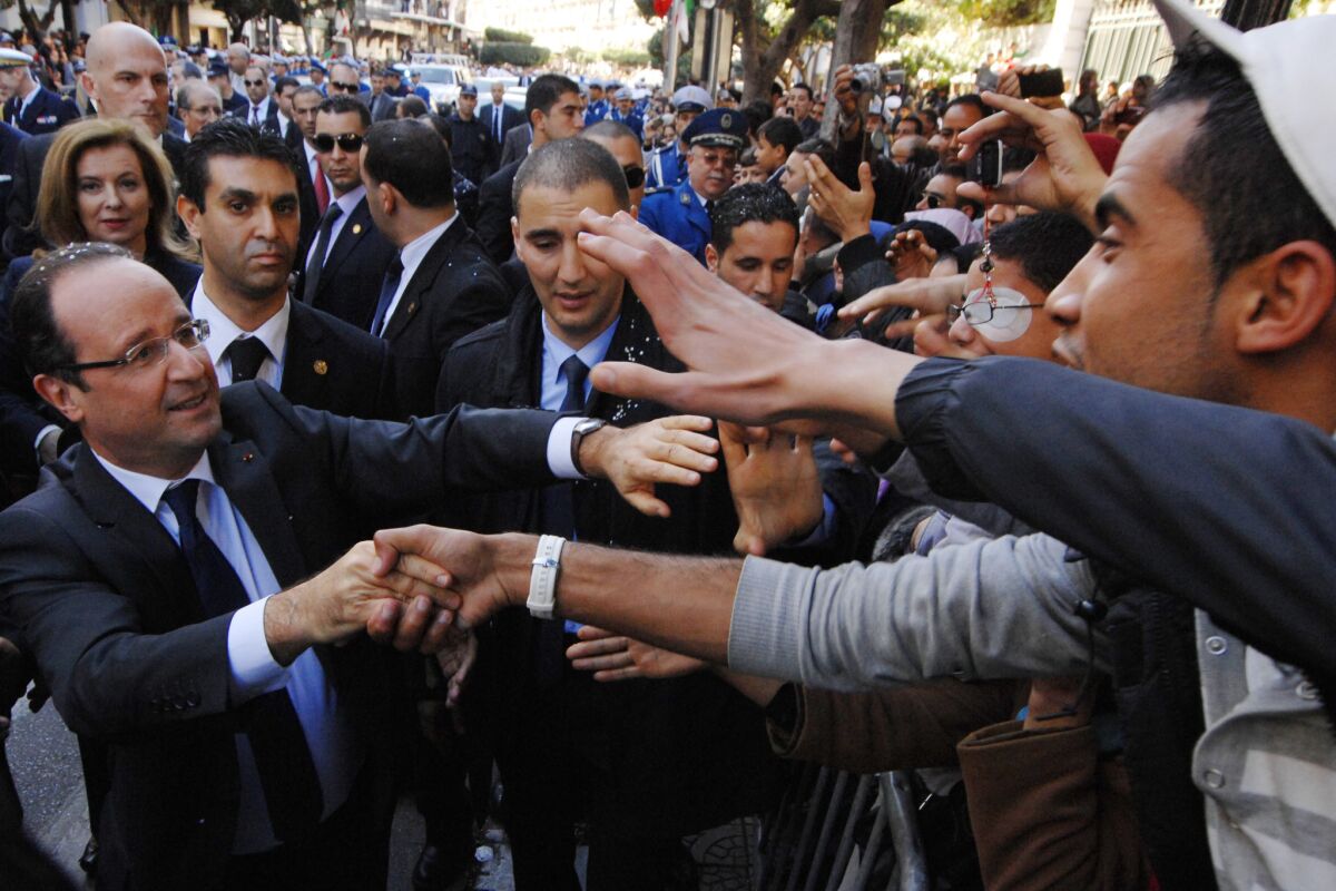 French President Francois Hollande, left, greets Algerians as he walks in Algiers on Thursday.