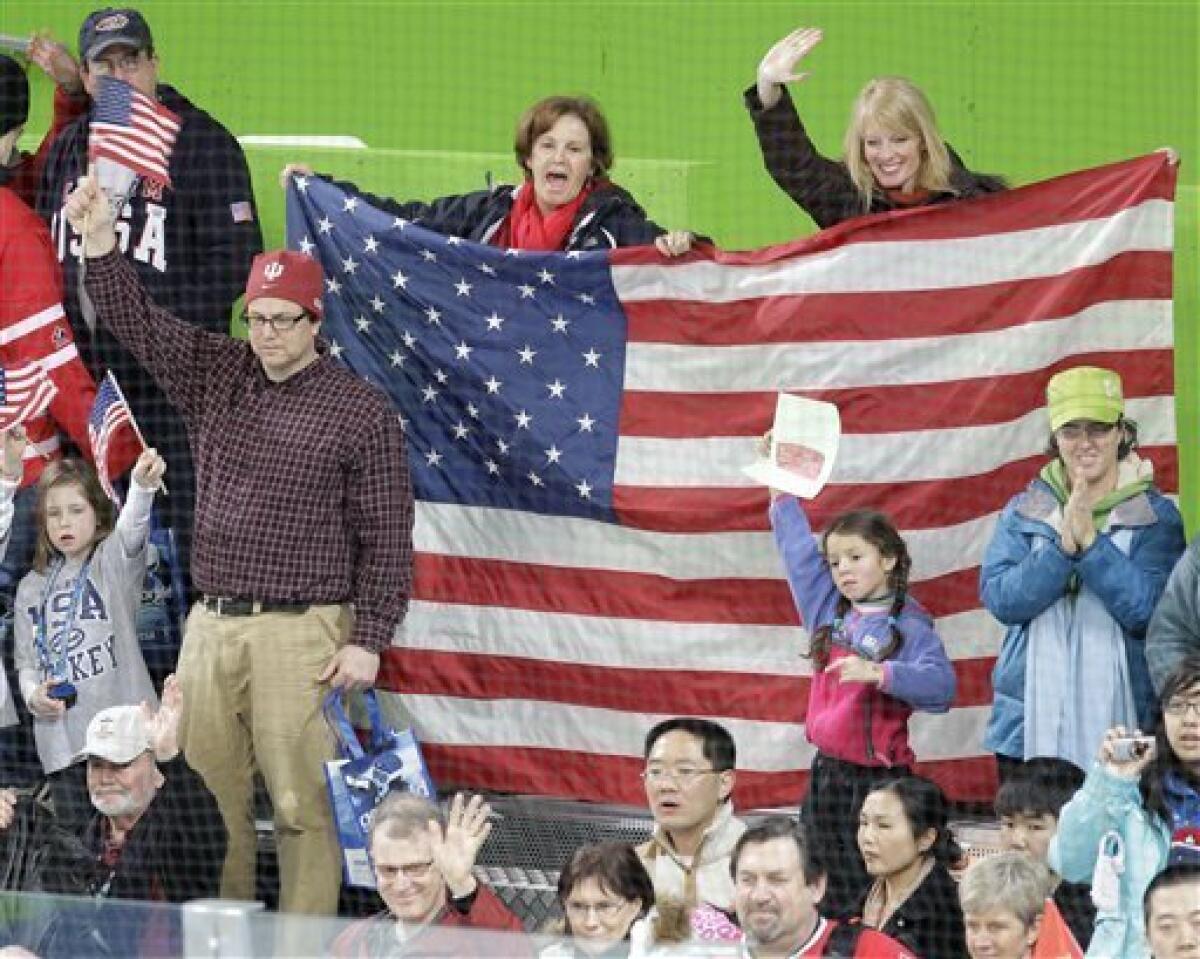 Fans holding an American flag cheer after the USA beat China 12-1 in women's preliminary round hockey play at the Vancouver 2010 Olympics in Vancouver, British Columbia, Sunday, Feb. 14, 2010. (AP Photo/Chris O'Meara)