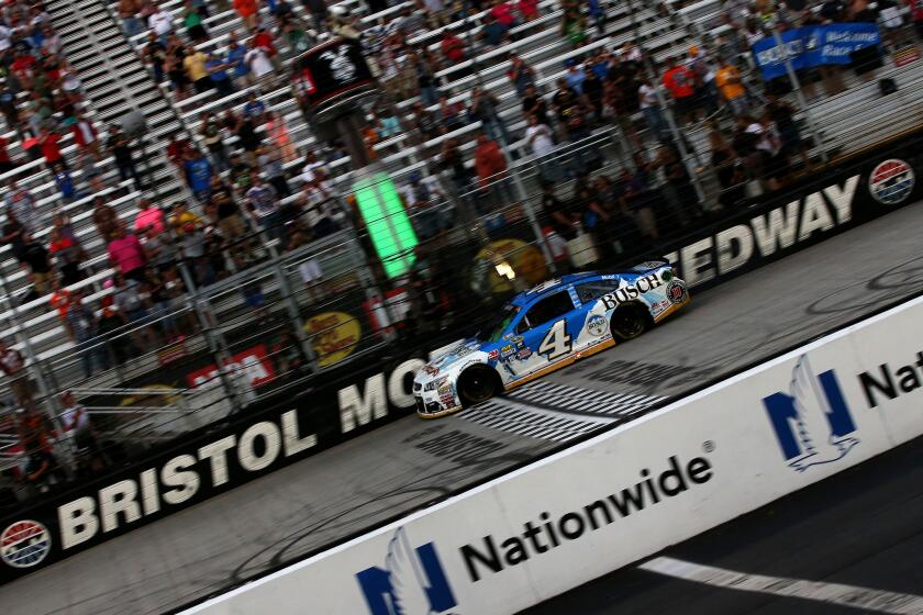Kevin Harvick, driver of the Busch Beer Chevrolet, takes the checkered flag to win the Bass Pro Shops NRA night race at Bristol Motor Speedway on Aug. 21.