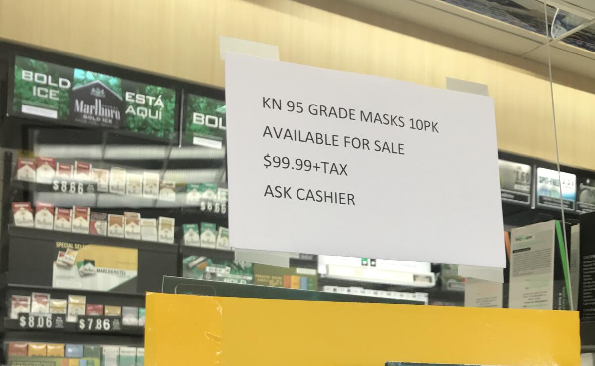 A sign advertising medical-grade face masks at a dramatically marked-up price is posted above a counter at a gas station in Bonita on Wednesday.