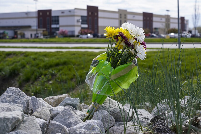 FILE - A single bouquet of flowers sits in the rocks across the street from the FedEx facility in Indianapolis, April 17, 2021, where eight people were shot and killed. The city of Indianapolis has effectively denied a request for over $2 million in compensation made by three members of the Sikh community affected by a mass shooting at the FedEx facility. The victims of the April 15 attack each requested $700,000 in damages from the city. They claimed that local officials failed to pursue a court hearing that could have prevented the shooter from accessing guns used in the attack. (AP Photo/Michael Conroy, File)