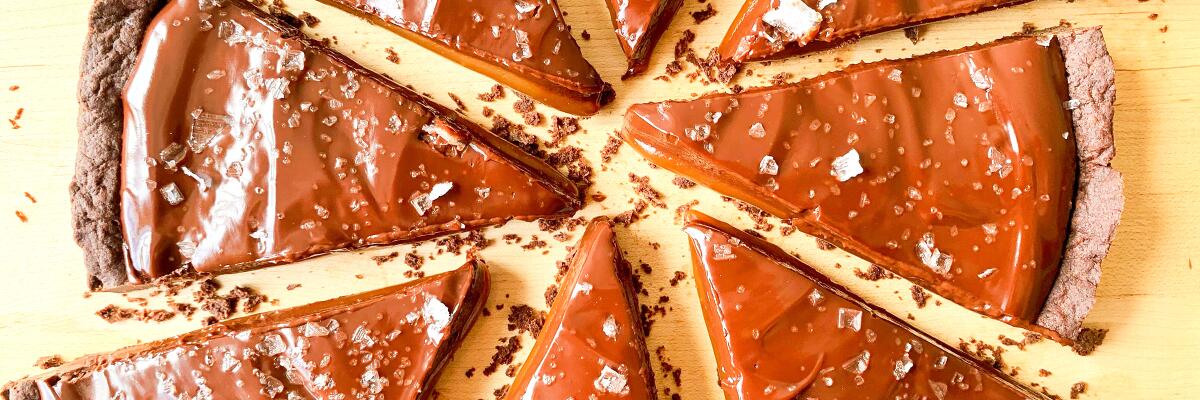 Caramel chocolate tart cut into wedges.