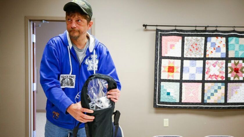 Danny Fouts, of Topmost, Ky., a former coal miner living with black lung disease, packs his portable oxygen machine on Dec. 19.