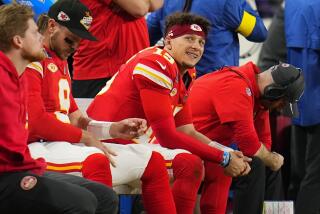 Kansas City Chiefs quarterback Patrick Mahomes smiles while sitting on the bench during the second half of the Super Bowl.
