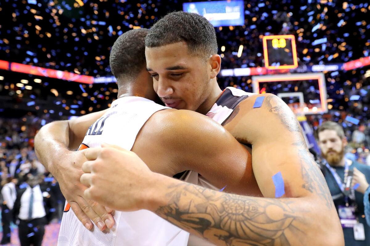 Virginia's Devon Hall, left, and Isaiah Wilkins celebrate after a win over North Carolina in the ACC tournament championship.