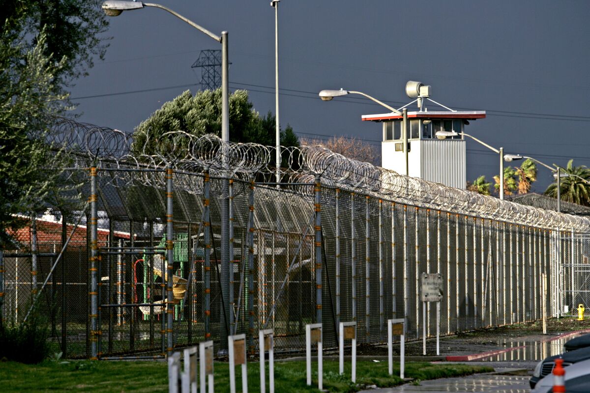 A prison, with tall fences, barbed wire, and a guard-tower
