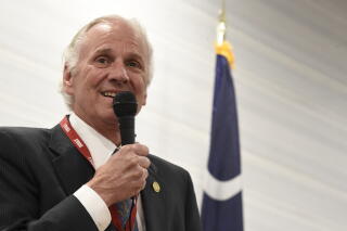 Former South Carolina Gov. Henry McMaster speaks into a handheld microphone.