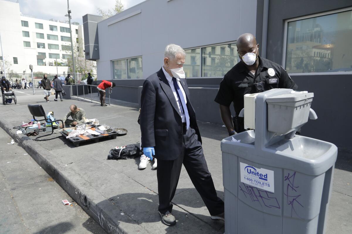 U.S. District Judge David O. Carter inspects an empty handwashing station while touring skid row on April 3. Garcetti has said the stations would help ensure hygiene practices among homeless Angelenos.