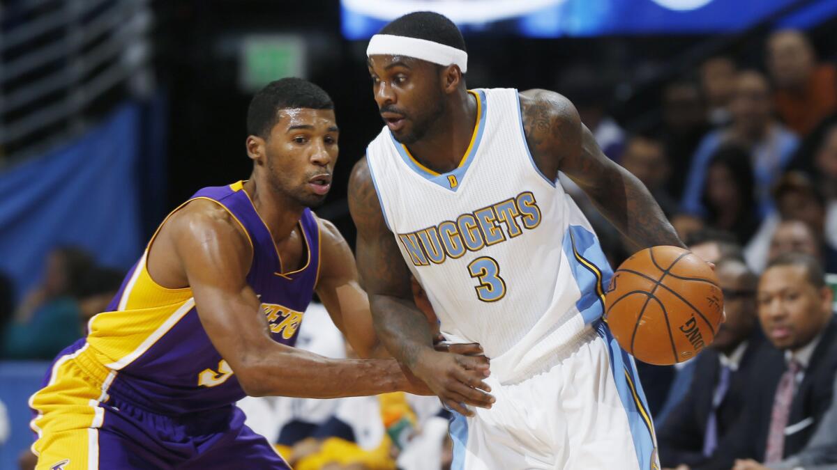 Denver Nuggets guard Ty Lawson, right, tries to work inside on Lakers guard Ronnie Price during a game in Denver on Dec. 30, 2014.