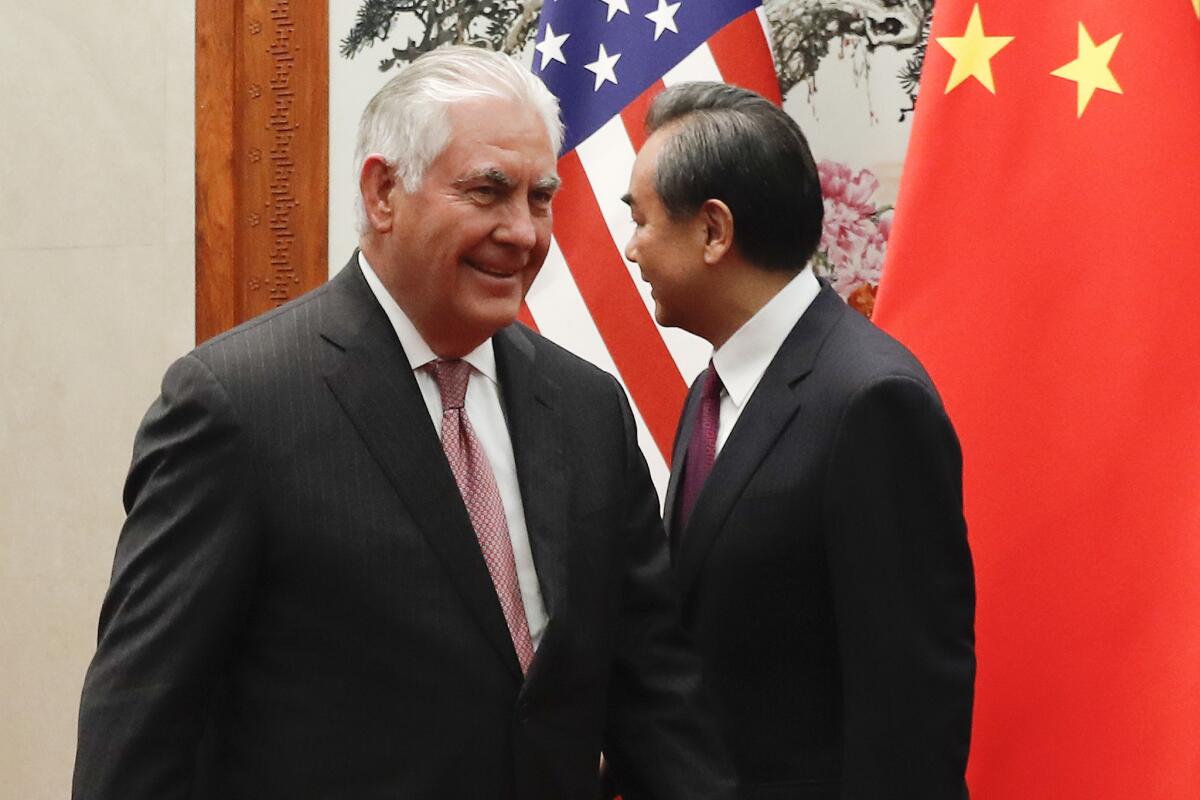 Secretary of State Rex Tillerson, in Beijing on Sept. 30 to discuss North Korea's nuclear program, walks by Chinese Foreign Minister Wang Yi.
