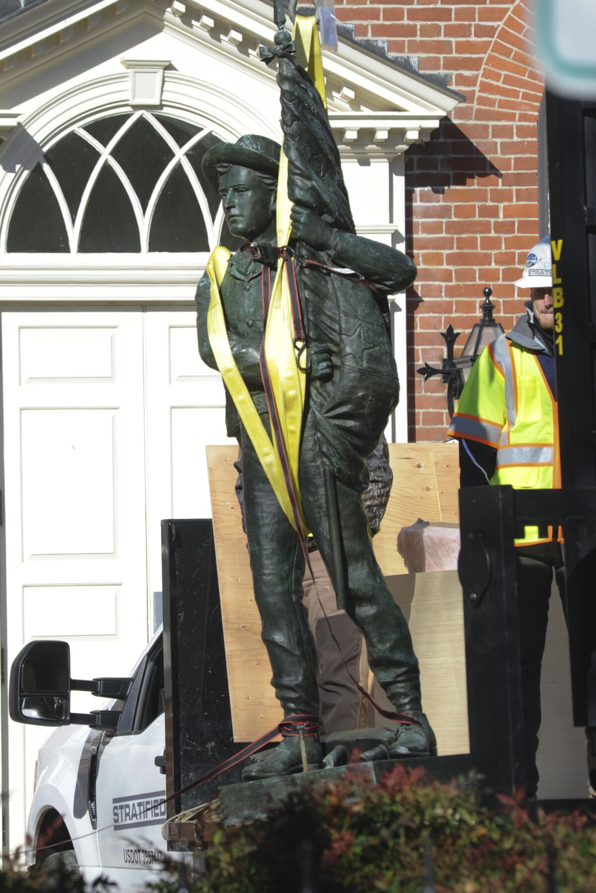 A crew removes the Talbot Boys Statue, Maryland's last public Confederate statue, on the grounds of the Talbot County Courthouse, Monday, March 14, 2022, in Easton, Md. The 13-foot tall, copper sculpture features a boy holding a Confederate flag and names the Talbot County men who joined the Confederacy and died in the war. (Tom McCall/Easton Star Democrat via AP)