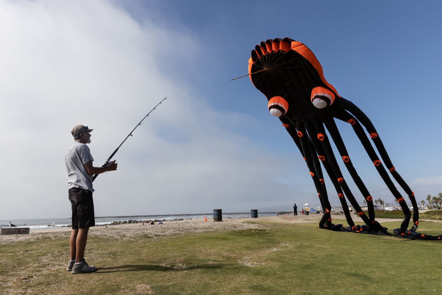 Mark Weiler flies a 75-foot-long octopus kite with a fishing rod at Ocean Beach on Wednesday, Sept. 28, 2022.