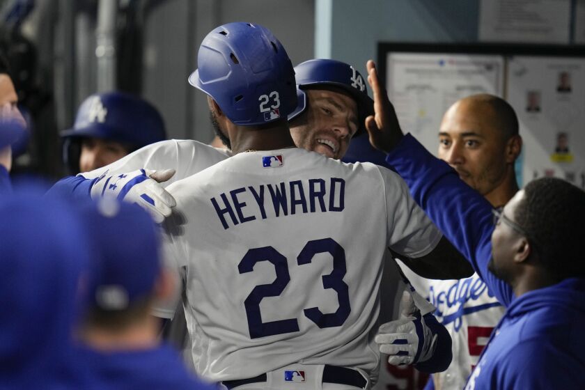 Freddie Freeman festeja con Jason Heyward, su compañero en los Dodgers de Los Ángeles, luego de batear un jonrón ante los Nacionales de Washington, el martes 30 de mayo de 2023 (AP Foto/Ashley Landis)