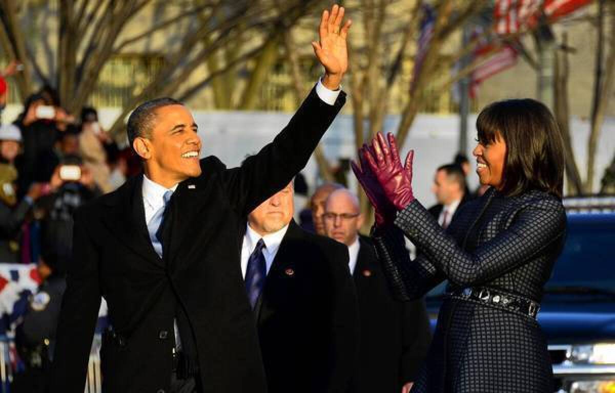 President Obama and First Lady Michelle Obama walk along the inauguration parade route.
