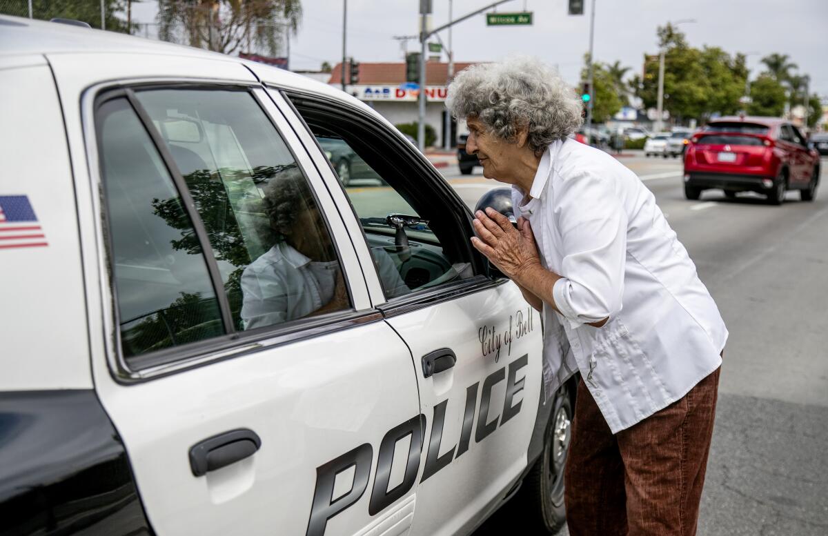 A woman speaks into an open police car window