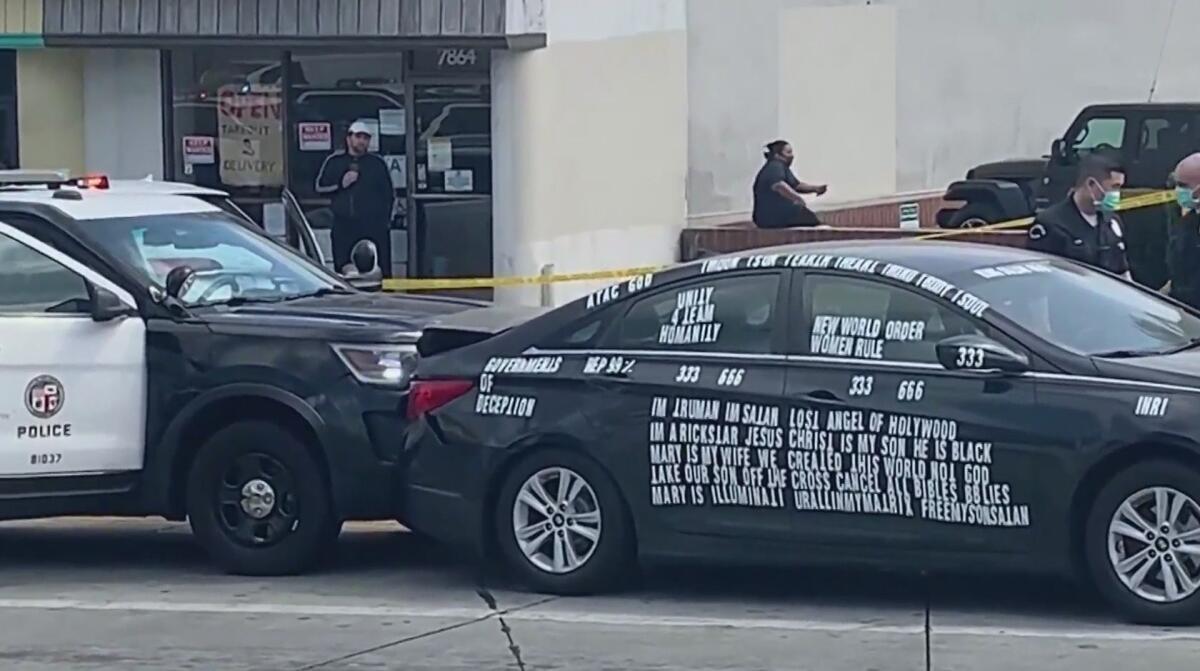 A police car is rammed into a car covered in decals. 