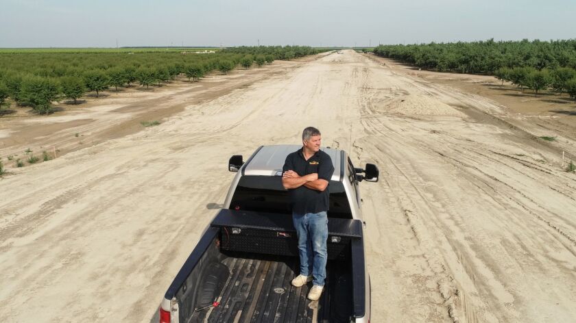 Farmer John Diepersloot stands in a swath of cleared peach orchards in the process of being developed for the bullet train project.