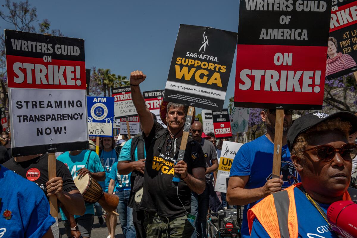 Members of SAG-AFTRA join striking writers on a picket line during a rally in Los Angeles on June 21.