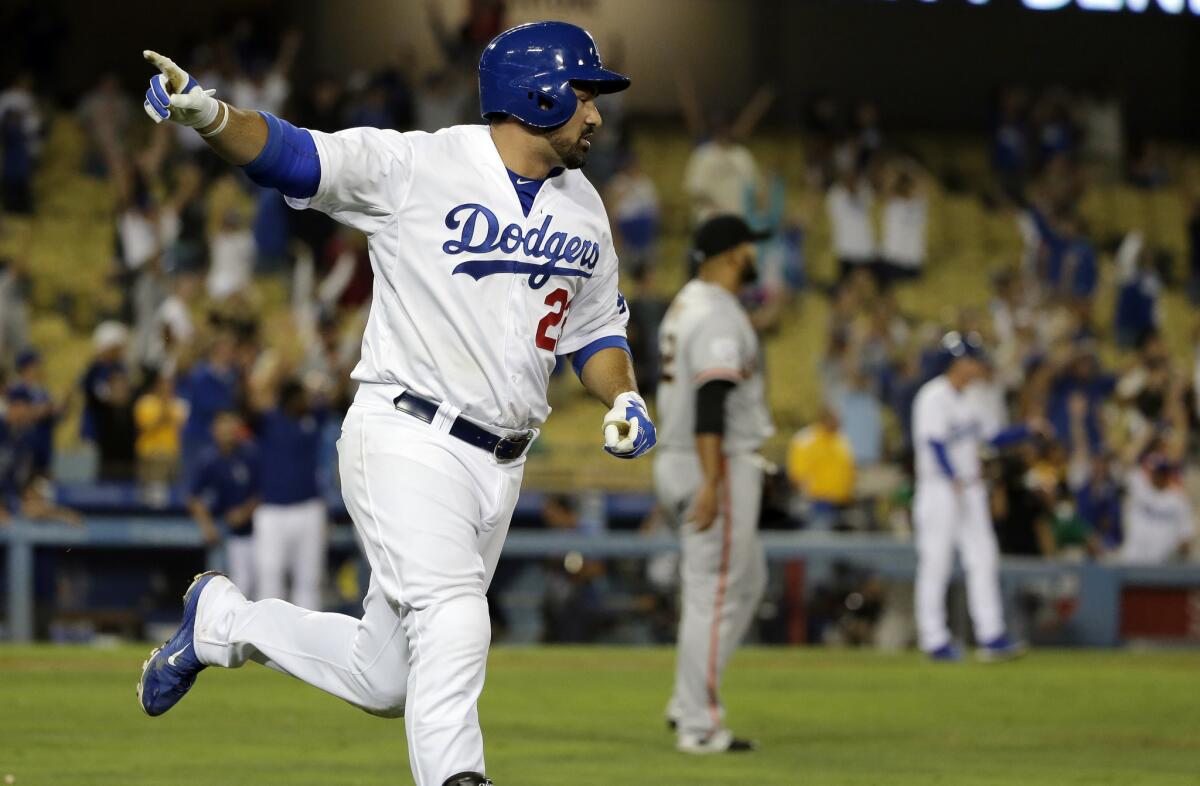 Los Angeles Dodgers' Adrian Gonzalez celebrates after scoring the game winning run on a single against the San Francisco Giants during the 14th inning of a baseball game in Los Angeles, Tuesday, Sept. 1, 2015. (AP Photo/Chris Carlson)