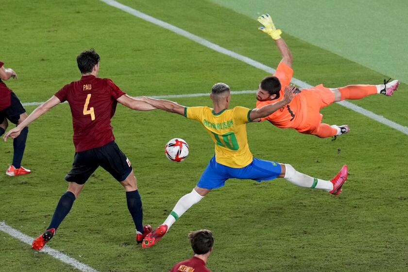 Spain's goalkeeper Unai Simon blocks and attack of Brazil's Richarlison in the men's soccer final match at the 2020 Summer Olympics, Saturday, Aug. 7, 2021, in Yokohama, Japan. (AP Photo/Martin Mejia)