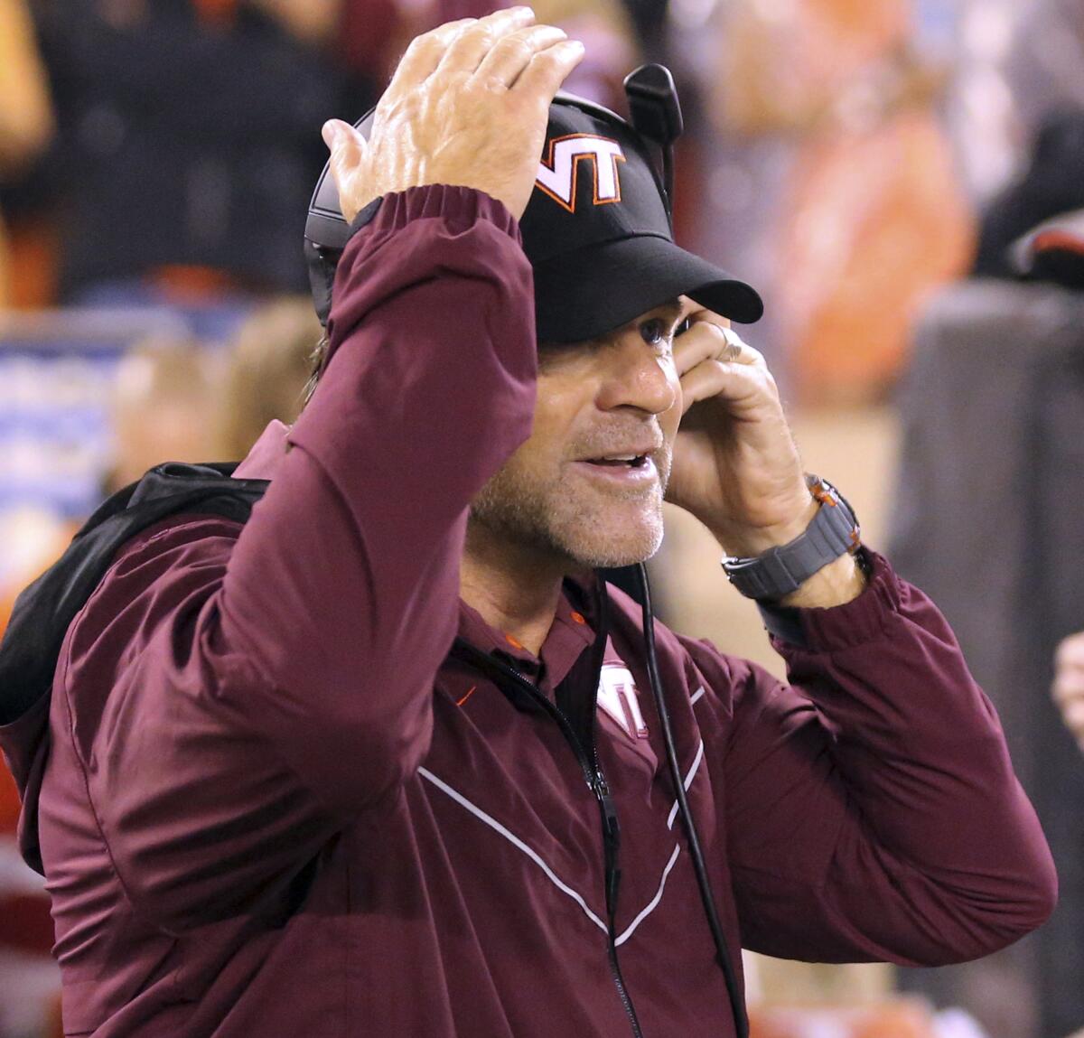 Virginia Tech coach Brent Pry puts on his headset at the start of the team's NCAA college football game against Boston College on Saturday, Sept. 10, 2022, in Blacksburg, Va. (Matt Gentry/The Roanoke Times via AP)