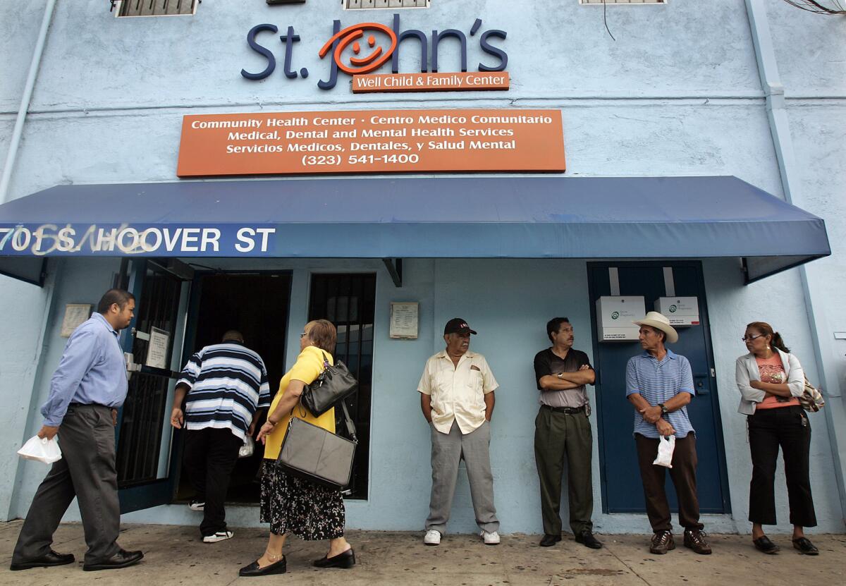 Patients line up as employees enter a St. John's Well Child and Family Center clinic in South L.A.