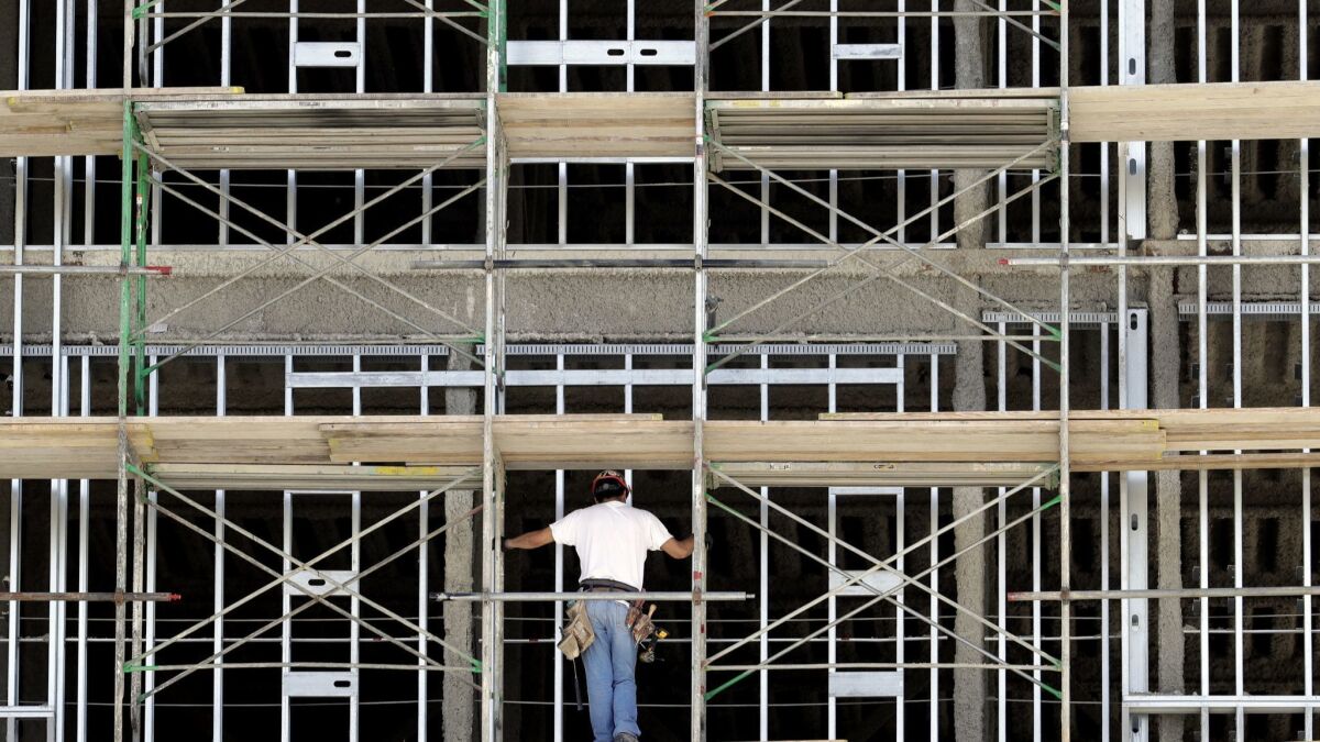 A worker helps build an apartment and retail complex in Nashville, Tenn., in 2017.