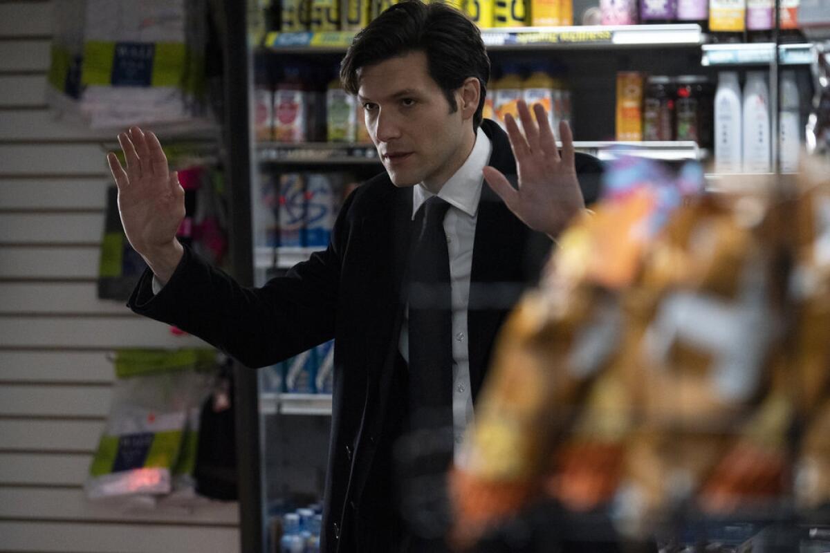 A man in a convenience store with his hands up.