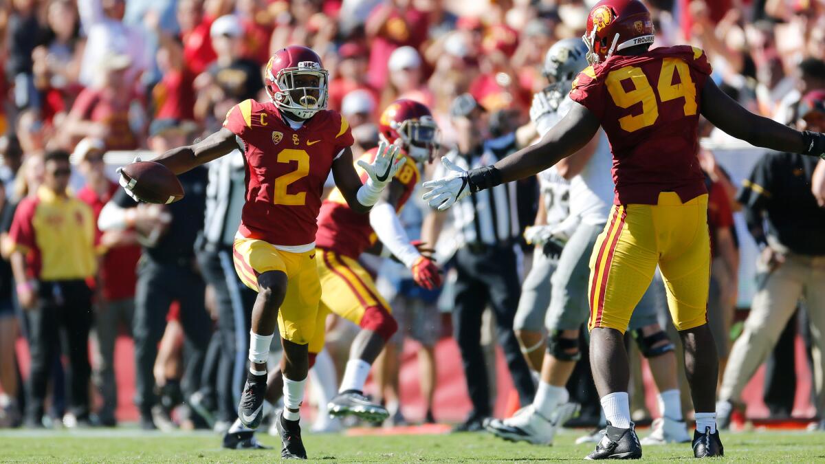 Adoree' Jackson, left, celebrates with Rasheem Green after intercepting a pass against Colorado on Saturday.
