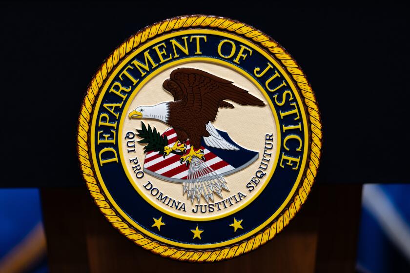 FILE - The U.S. Department of Justice logo is seen on a podium before a news conference, May 4, 2026, in Washington. (AP Photo/Julia Demaree Nikhinson, File)