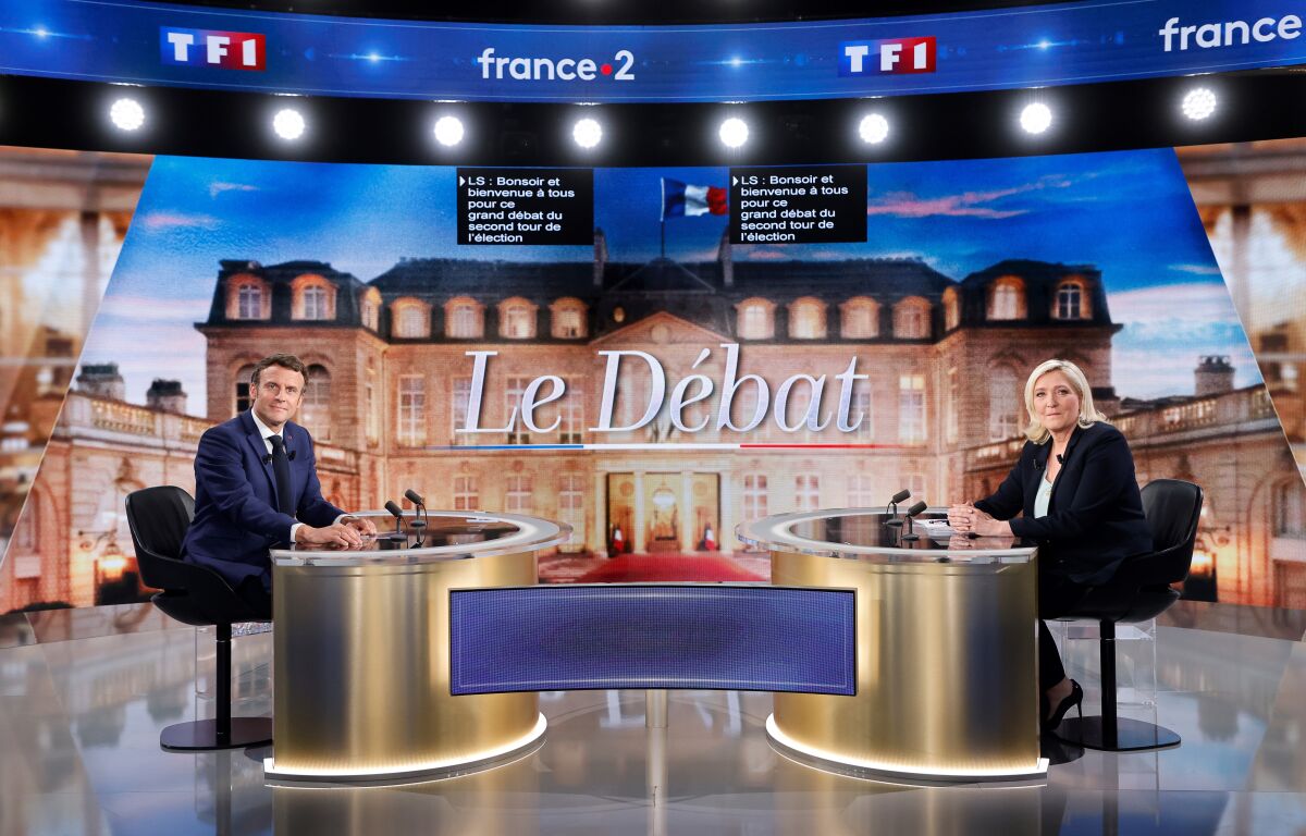 Centrist candidate and French President Emmanuel Macron, left, and far-right contender Marine Le Pen pose before a televised debate in La Plaine-Saint-Denis, outside Paris, Wednesday, April 20, 2022. In the climax of France's presidential campaign, centrist President Emmanuel Macron and far-right contender Marine Le Pen meet Wednesday evening in a one-on-one television debate that could prove decisive before Sunday's runoff vote. (Ludovic Marin, Pool via AP)