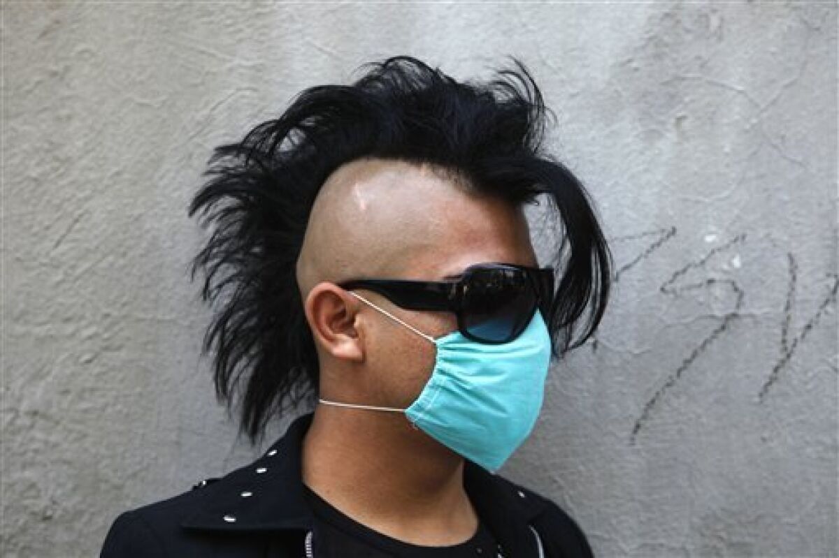 A punk, wearing a face mask as a precaution against swine flu, looks on in Mexico City, Saturday May 2, 2009. (AP Photo/Eduardo Verdugo)