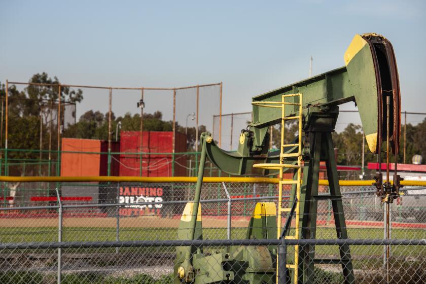 Los Angeles, CA - January 26: An Oil derrick pump is seen near a baseball diamond in the Wilmington Athletic Complex, in the Wilmington neighborhood of Los Angeles, CA, Wednesday, Jan. 26, 2022. The Los Angeles City Council voted Wednesday to ban new oil and gas wells and to phase out existing wells over a five-year period.(Jay L. Clendenin / Los Angeles Times)