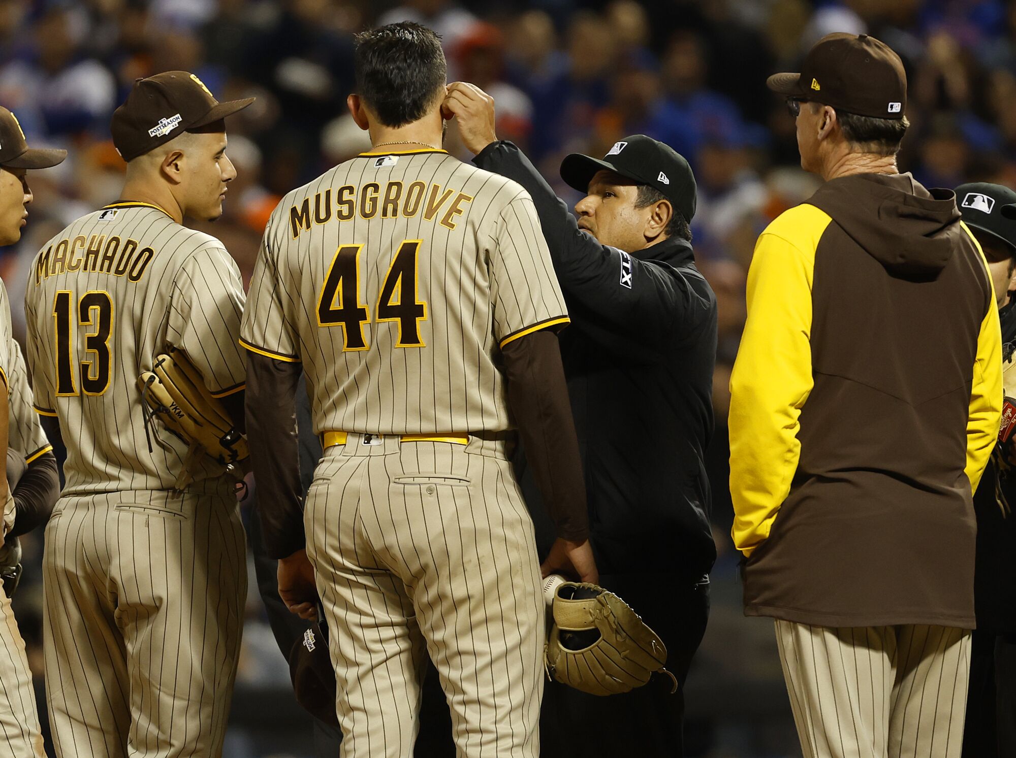 Umpires check Padres pitcher Joe Musgrove after the Mets requested a substance check.