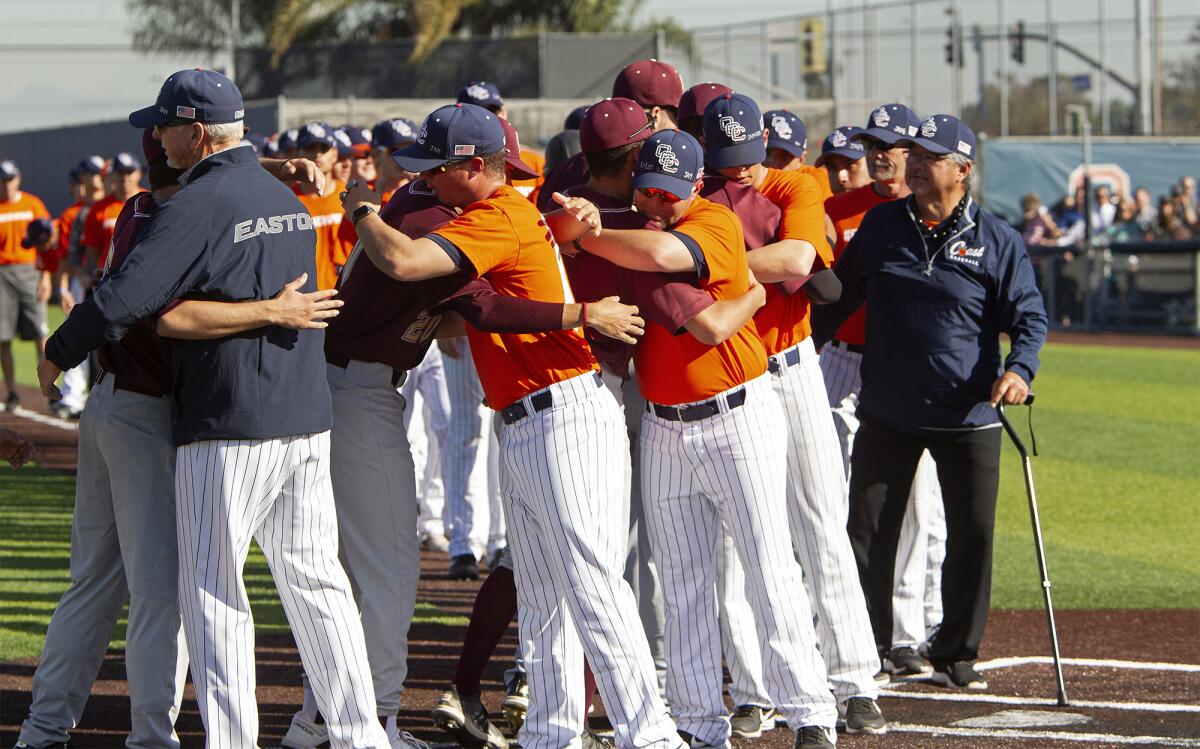 Orange Coast College players and coaches share hugs with Southwestern after recognizing late longtime Pirates coach John Altobelli before Tuesday's home game.