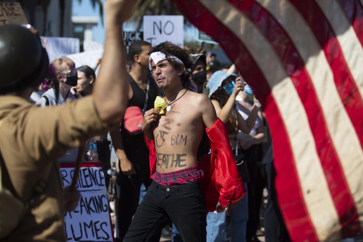 Hundreds of protesters gather in Huntington Beach on Sunday. Various police agencies were on scene. Nonlethal rounds were fired from a rooftop and on the ground, and the crowd cleared.