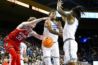 Utah center Branden Carlson battles for the rebound with UCLA guards Dylan Andrews and Brandon Williams.