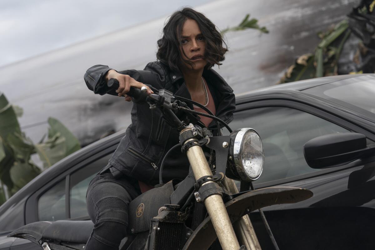 Michelle Rodriguez rides a motorcycle in a scene from "F9" a.k.a. "Fast & Furious 9."
