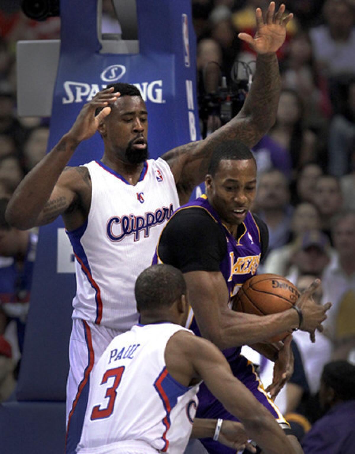 Clippers center DeAndre Jordan and point guard Chris Paul double team Lakers center Dwight Howard during their game Sunday afternoon.