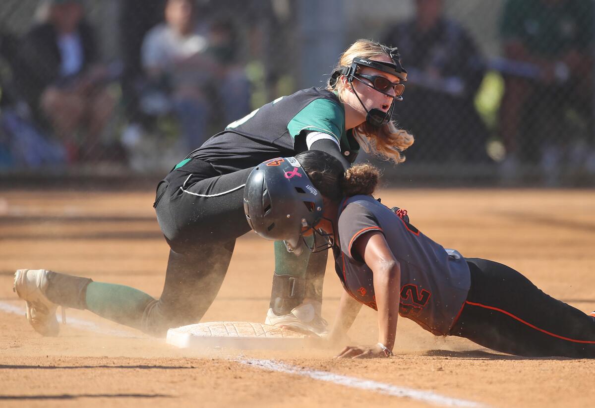 Zariah Billinger (42) of Huntington Beach dives back to first safely as Murrieta Mesa's Kailyn Holtkamp applies a tag.