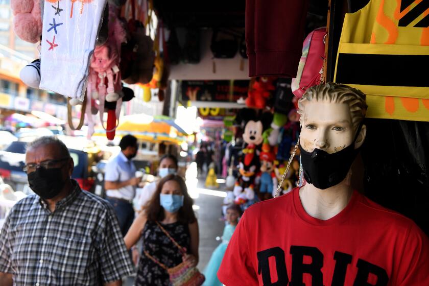 LOS ANGELES, CALIFORNIA NOVEMBER 17, 2020-People wearing masks shop along Maple Ave. in the Santee area of Downtown Los Angeles as the coronavirus surges Tuesday. (Wally Skalij/Los Angeles Times)