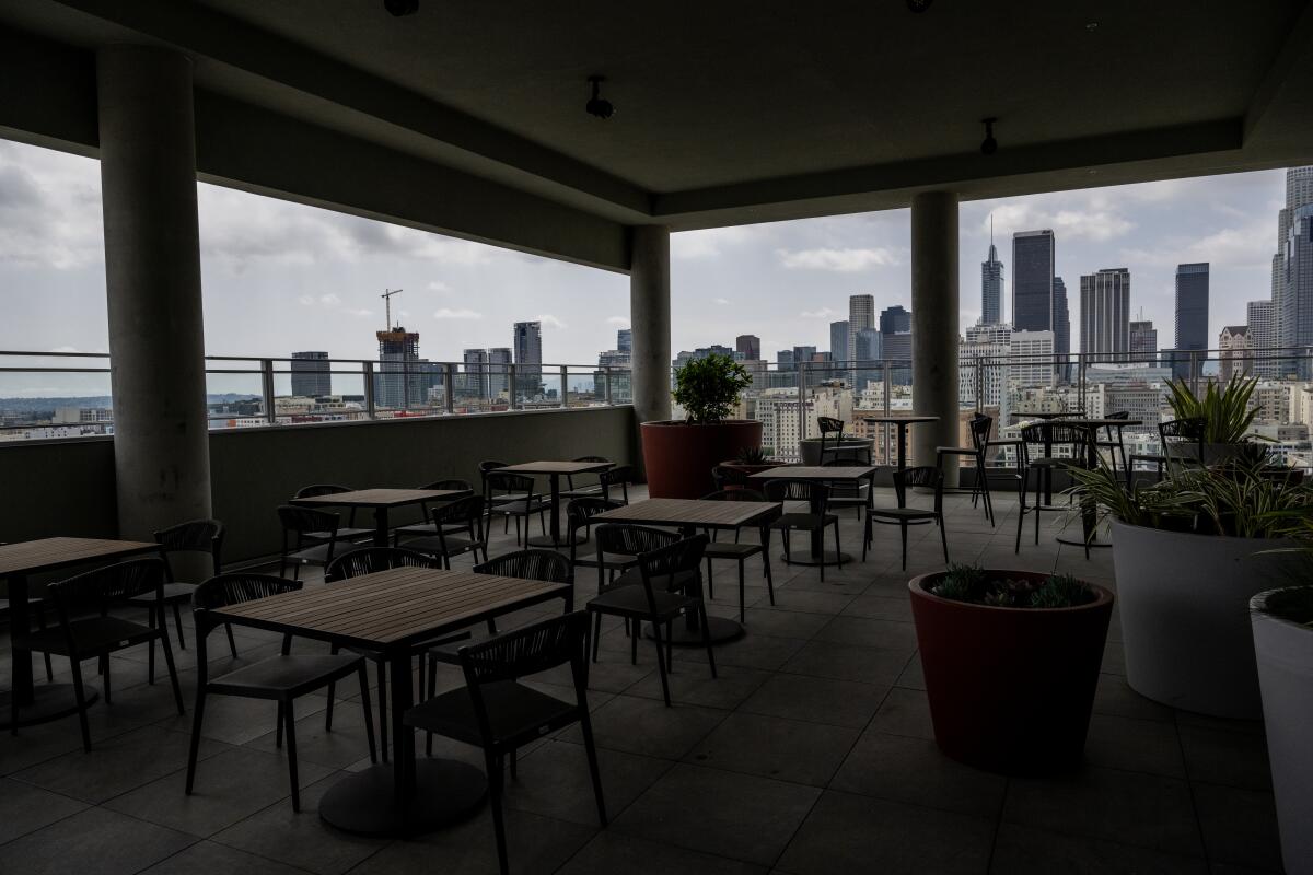 A patio with tables and a view of downtown L.A. 