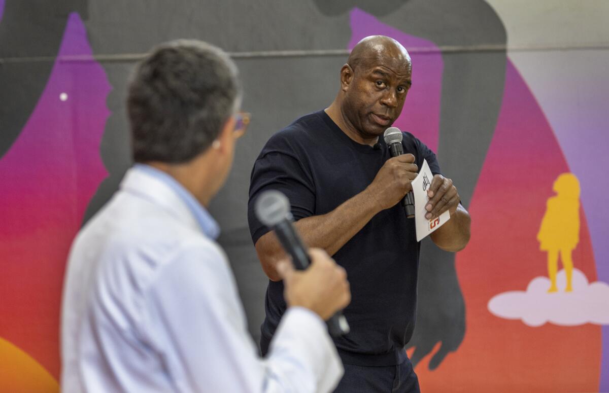 Magic Johnson, right, and Dr. Len Friedland speak about RSV to a gathering at the Crenshaw Family YMCA on Tuesday.