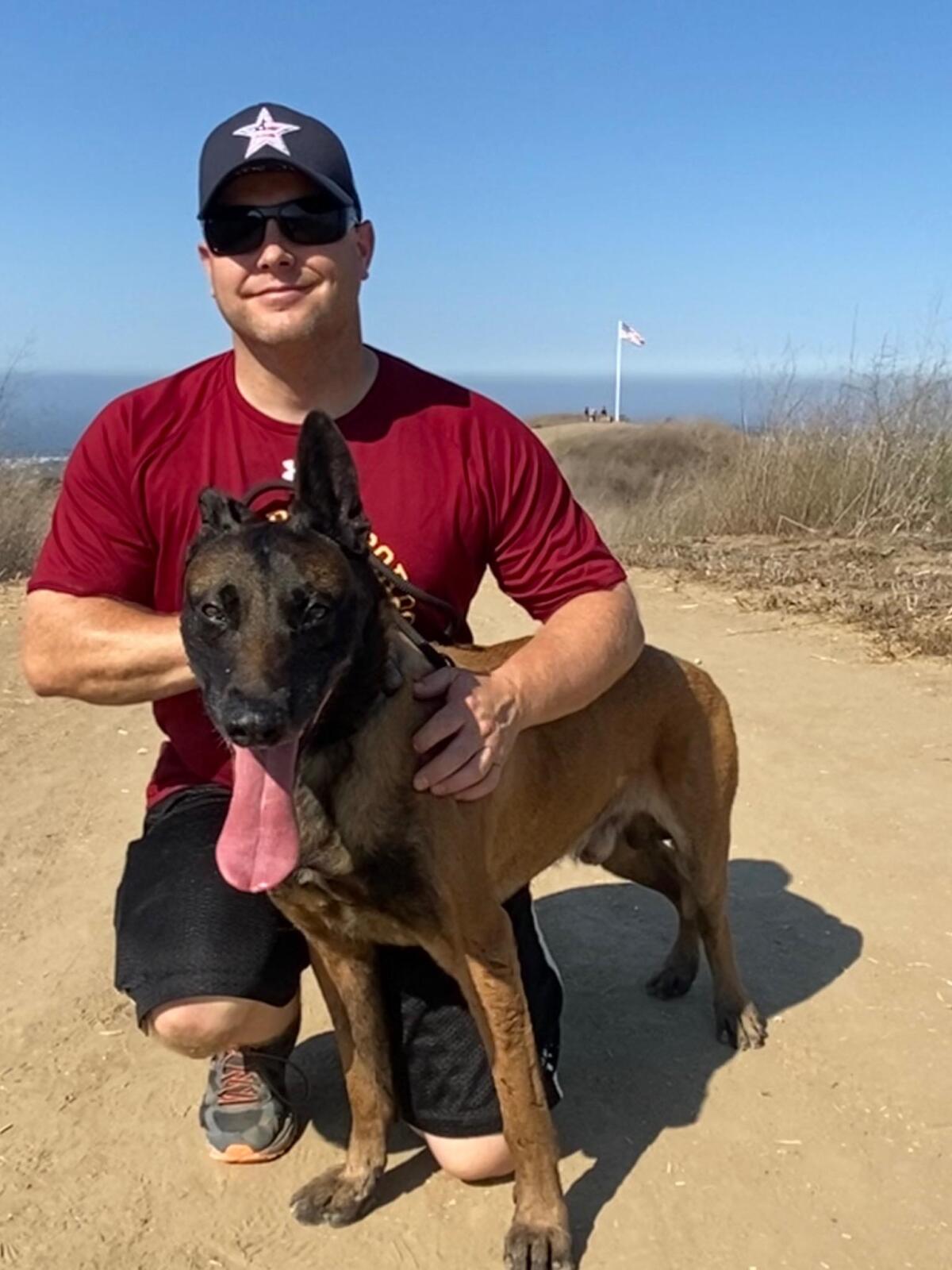 Huntington Beach Police Officer Wade Wilson poses for a photo with Marco.