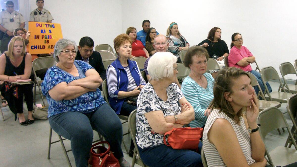 Residents of Jim Wells County listen to comments during a public meeting about a proposal to turn an abandoned nursing home into a family immigrant detention center.