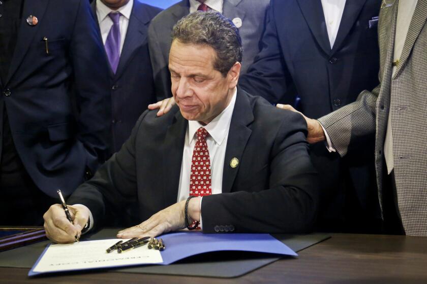 FILE - In this April 10, 2017, file photo, New York Gov. Andrew Cuomo signs new legislation for free state college tuition and juvenile justice reform, during a signing ceremony in New York. Even as higher education experts applaud the concept, they question some of the fine print of New York's plan and whether it is indeed a model that should be replicated elsewhere. New York's plan would cover in-state public college tuition for full-time students whose families earn $125,000 or less. But there are questions whether more should be done for the poorest students, and to pay for the many college costs beyond tuition. (AP Photo/Bebeto Matthews, File)