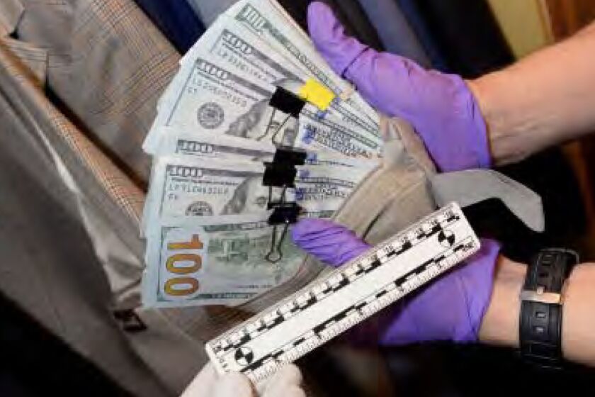 The photograph above documents cash found in L.A. City Councilman Jose Huizar's residence, including cash inside a suit jacket pocket.