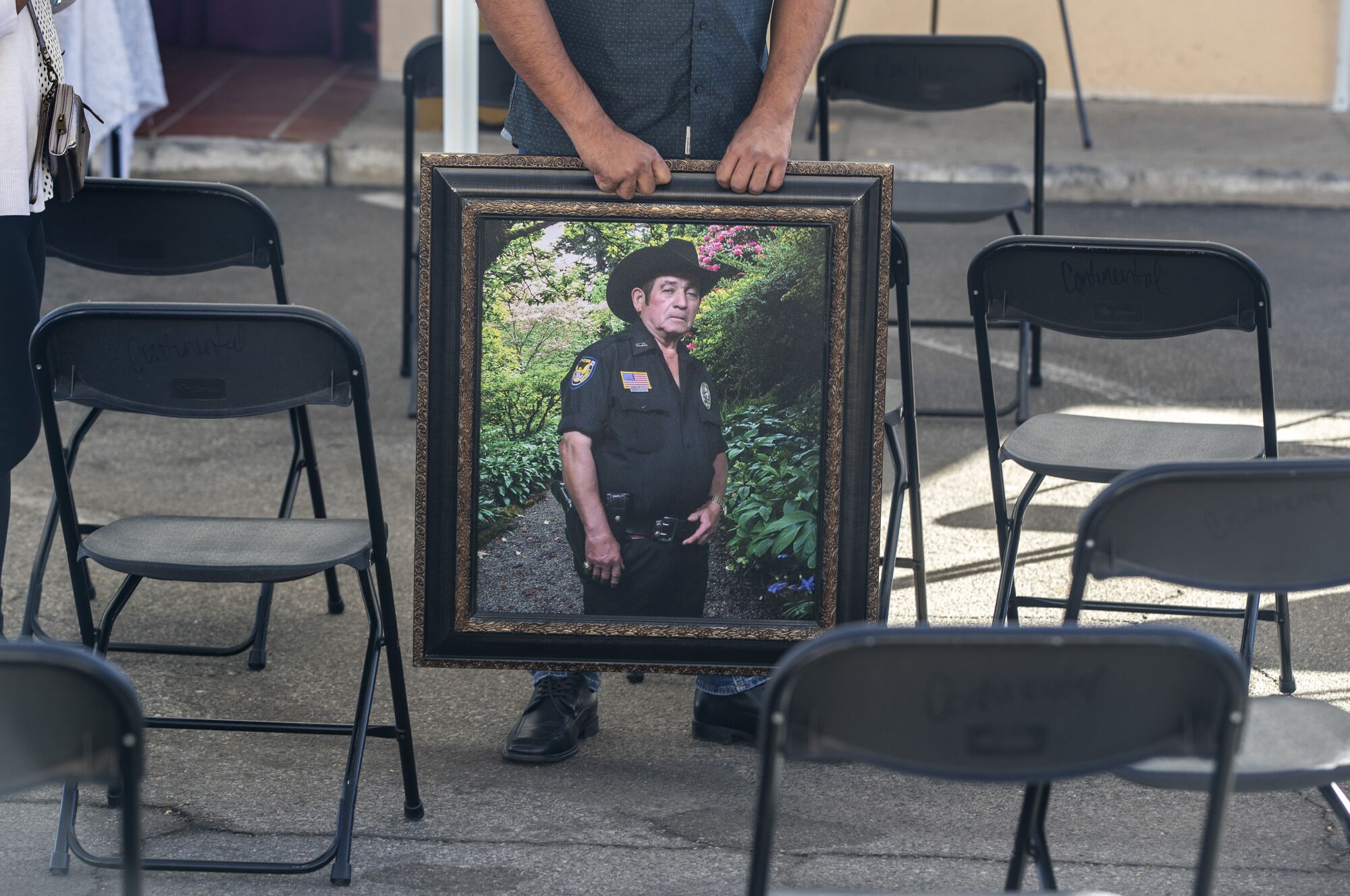 A family member holds a portrait of Julio Aguilar at Continental Funeral Home in East Los Angeles. 