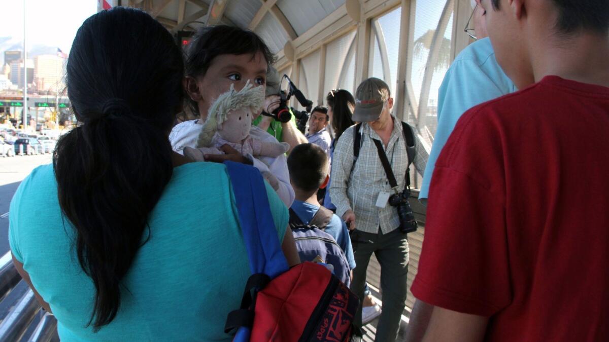 A Mexican woman holds her grandchild as she walks across the Paso Del Norte Port of Entry near El Paso on Wednesday.