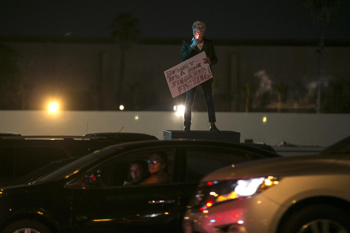 Bax Baxter lights a cigarette as he stands along S. Harbor Blvd. across the street where a few dozen demonstrators and homeless advocates rally in solidarity with those experiencing homelessness and Disneyland workers struggling with poverty wages.